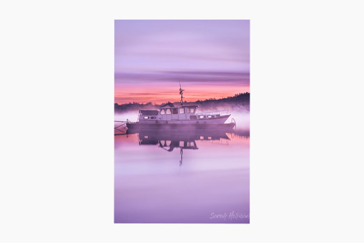 Boat on foggy water in the early mornings shortly before sunrise